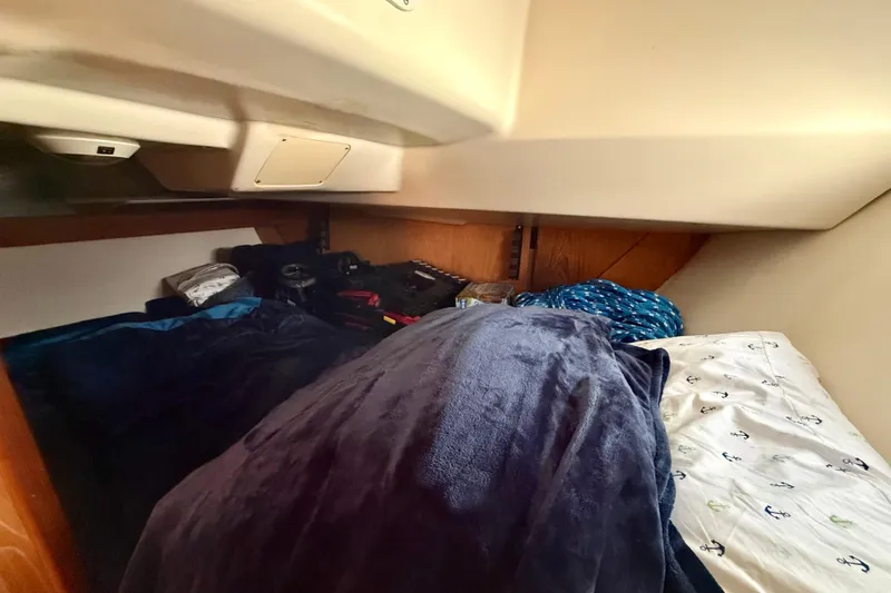 Slide: The Image of Cozy cabin interior of a 2000 Hunter 290 sailboat with bedding and storage. - 11