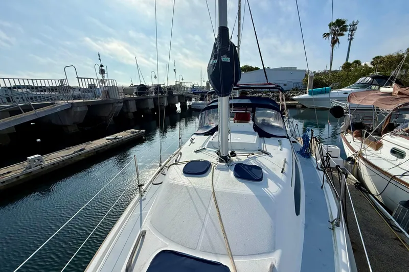 Slide: The Image of Sailboat Hunter 290, 2000 model, docked at marina with clear sky and calm waters. - 16