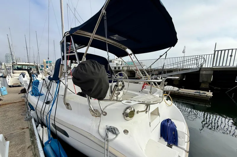 Slide: The Image of Sailboat Hunter 290, 2000 model, docked at marina with blue canopy and equipment. - 19