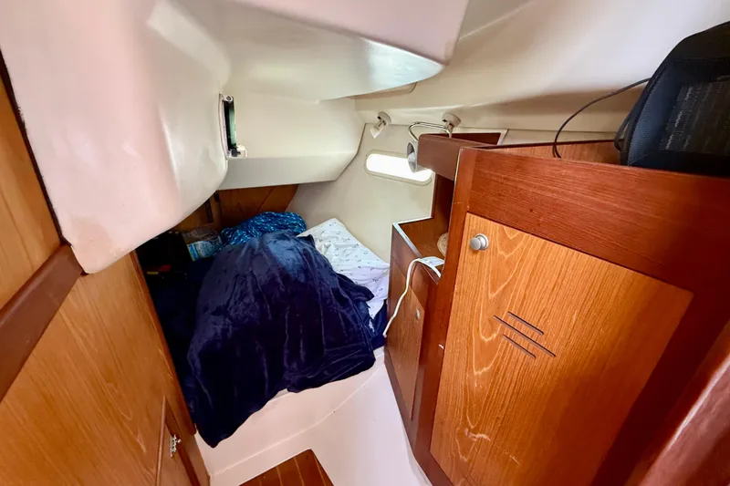 Slide: The Image of Cozy cabin interior of 2000 Hunter 290 sailboat with wooden cabinetry and bedding. - 3