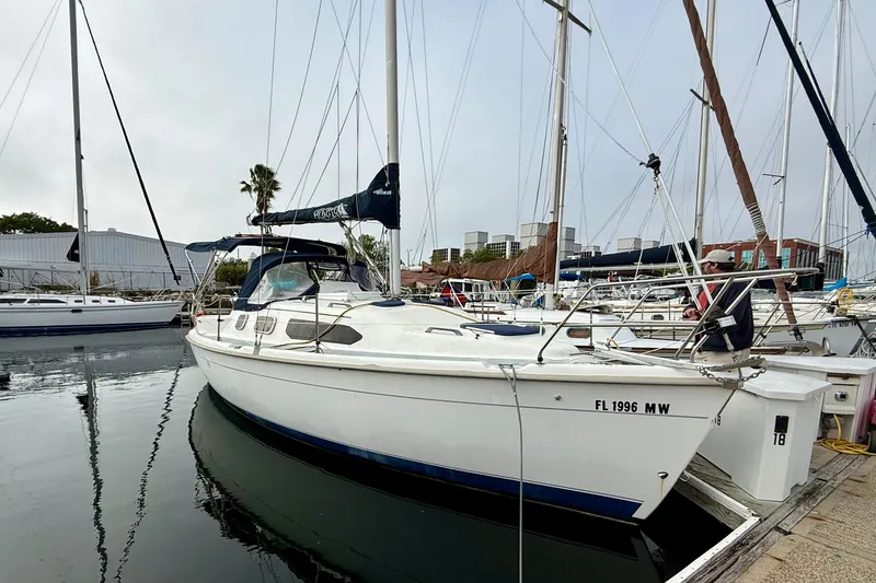 Slide: The Image of 2000 Hunter 290 sailboat docked in marina, surrounded by other boats. - 4