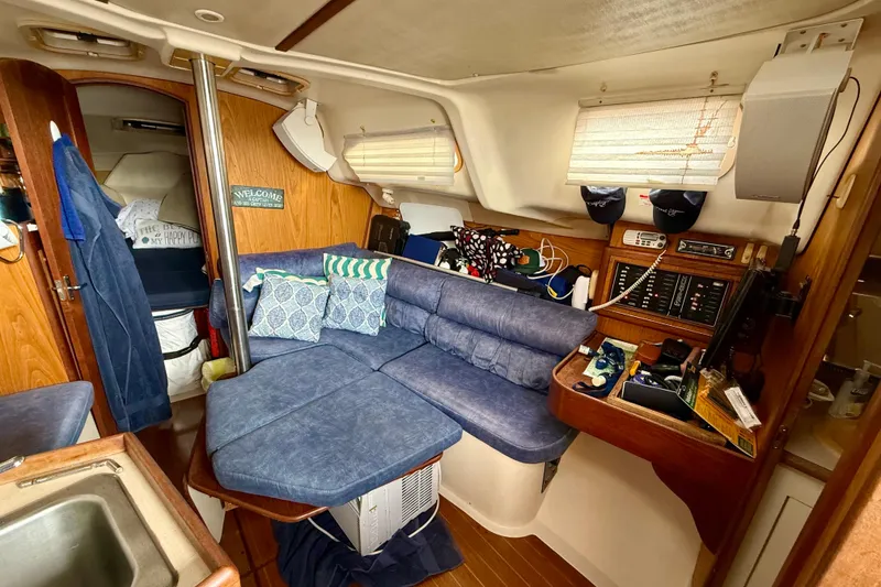 Slide: The Image of Cozy interior of a 2000 Hunter 290 sailboat with blue seating and wooden accents. - 6