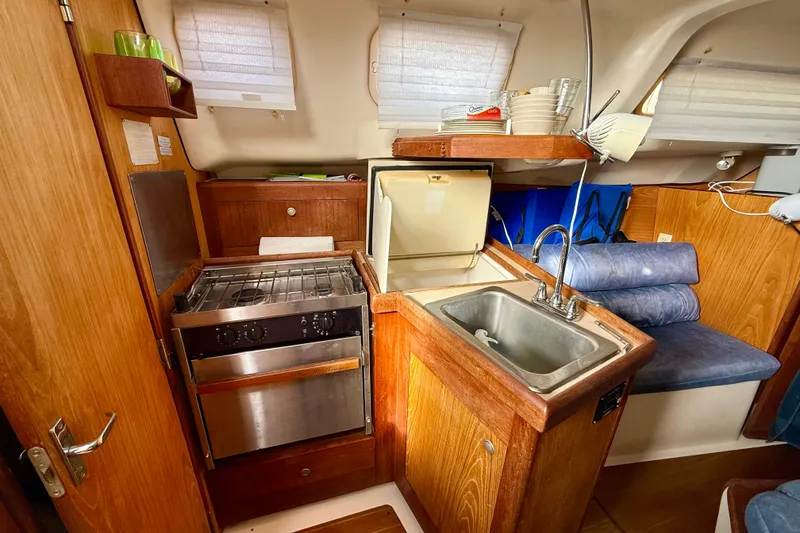 Slide: The Image of Compact kitchen area in a 2000 Hunter 290 sailboat with stove, sink, and storage. - 8