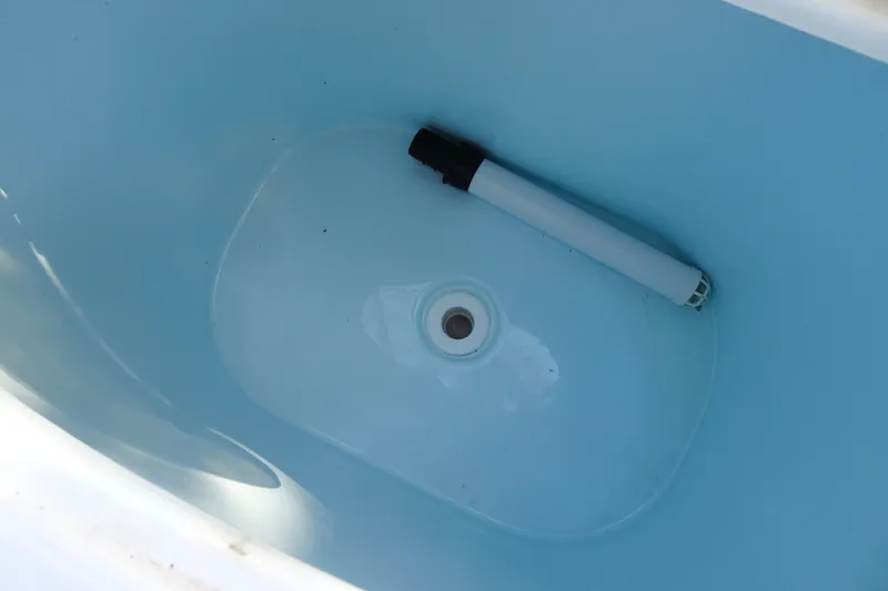 Slide: The Image of Livewell interior of 2007 Sea Hunt Triton 232 boat, featuring a drain and pipe. - 17