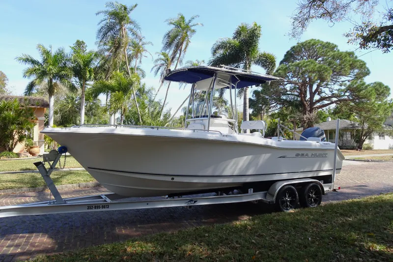 Slide: The Image of 2007 Sea Hunt Triton 232 boat on trailer, surrounded by palm trees. - 21
