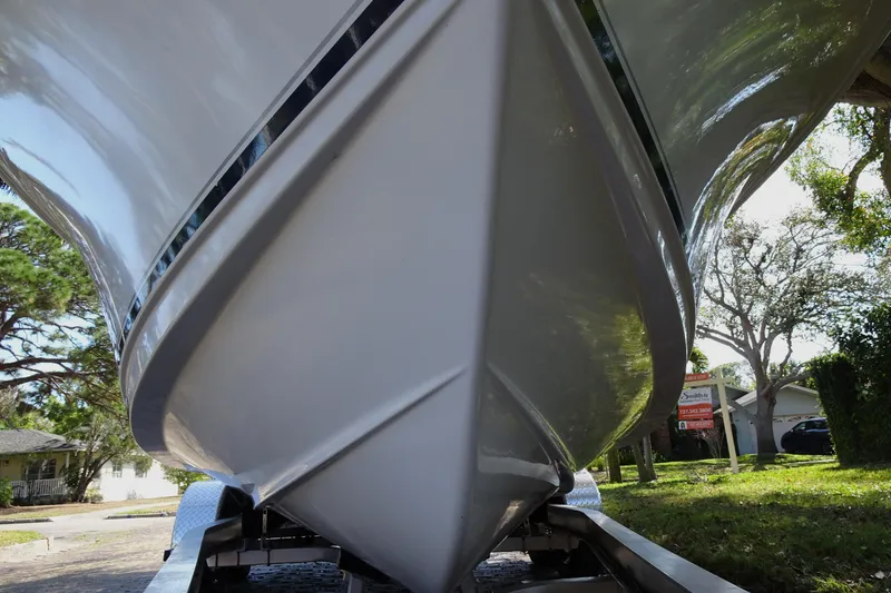 Slide: The Image of 2007 Sea Hunt Triton 232 boat on trailer, viewed from below, with trees in background. - 6