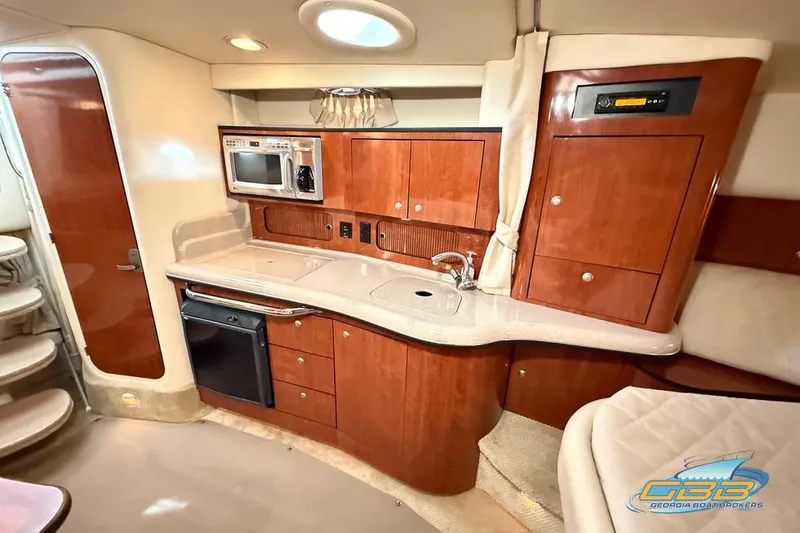 Slide: The Image of 2007 Sea Ray Sundancer 320 interior with kitchenette, featuring wood cabinetry and modern appliances. - 14