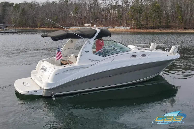 Slide: The Image of 2007 Sea Ray Sundancer 320 cruising on a calm lake with trees in the background. - 2