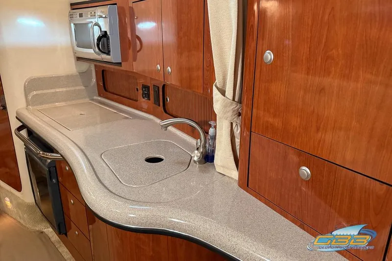 Slide: The Image of 2007 Sea Ray Sundancer 320 interior kitchen with wood cabinets and modern appliances. - 23