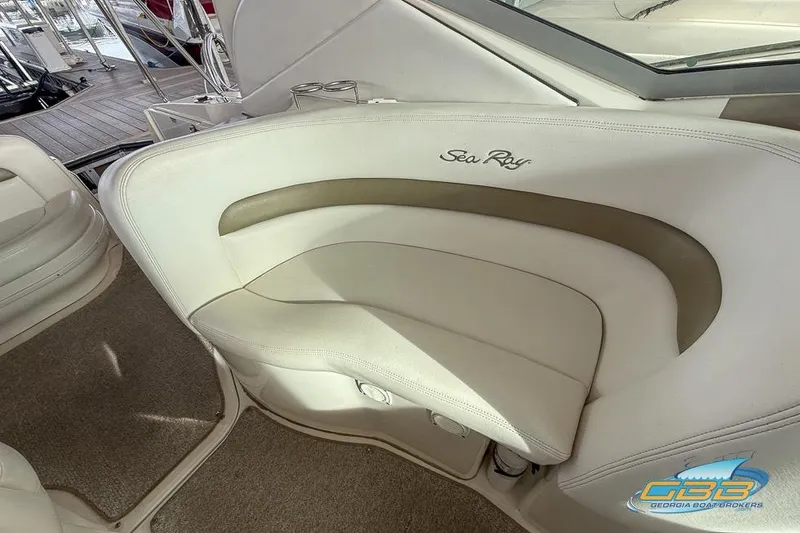 Slide: The Image of 2007 Sea Ray Sundancer 320 interior seating with logo, featuring beige upholstery. - 43