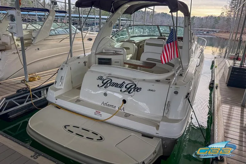 Slide: The Image of 2007 Sea Ray Sundancer 320 docked, featuring spacious deck and American flag. - 48
