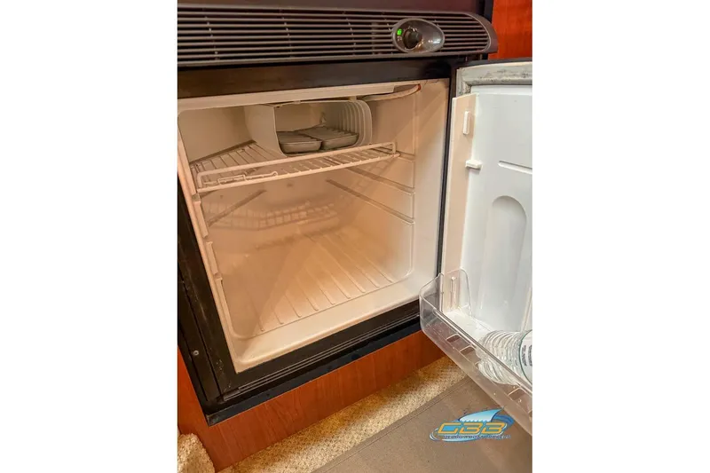 Slide: The Image of Open refrigerator inside 2007 Sea Ray Sundancer 320 yacht, showing empty shelves. - 49