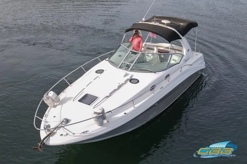 Slide: The Image of 2007 Sea Ray Sundancer 320 boat on calm water, featuring sleek design and black canopy. - 9