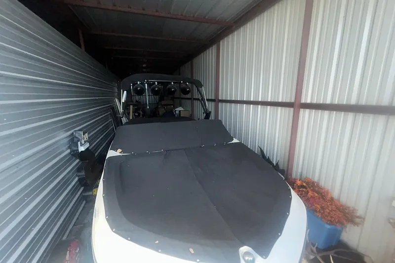 Slide: The Image of 2017 Bayliner VR6 Bowrider I/O stored in a metal shed, covered with a black tarp. - 10