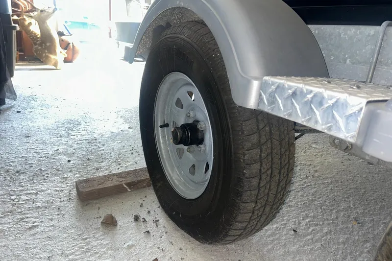 Slide: The Image of Trailer wheel of a 2017 Bayliner VR6 Bowrider I/O in a garage setting. - 34