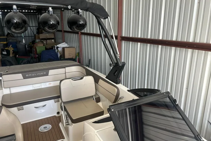 Slide: The Image of 2017 Bayliner VR6 Bowrider I/O interior with seating and storage in a metal shed. - 6