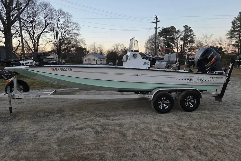 The Image of 2023 Xpress H22B Bay boat on trailer, parked outdoors at sunset. - 0