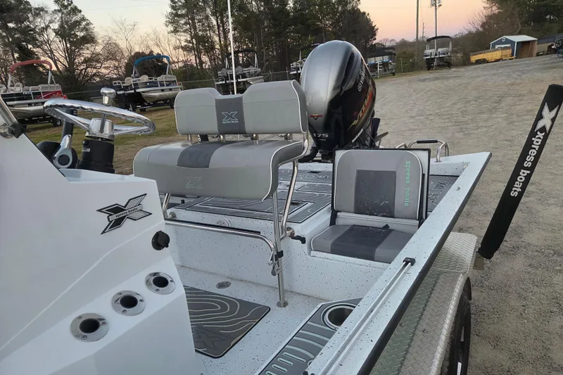 Slide: The Image of 2023 Xpress H22B Bay boat with seating and motor, parked on a trailer. - 11