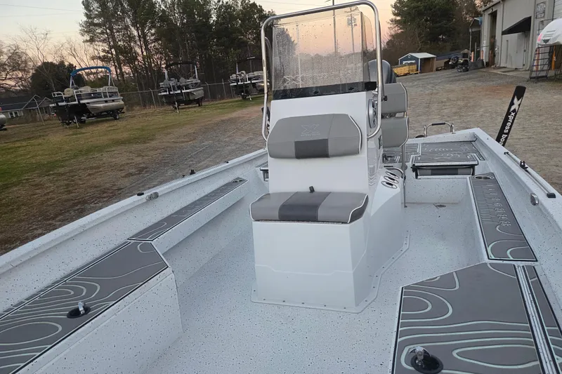 Slide: The Image of 2023 Xpress H22B Bay boat with sleek interior design, parked outdoors. - 14
