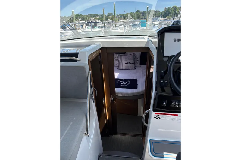 Slide: The Image of 2020 Jeanneau NC 895 cabin interior with cozy bedding and helm view. - 13