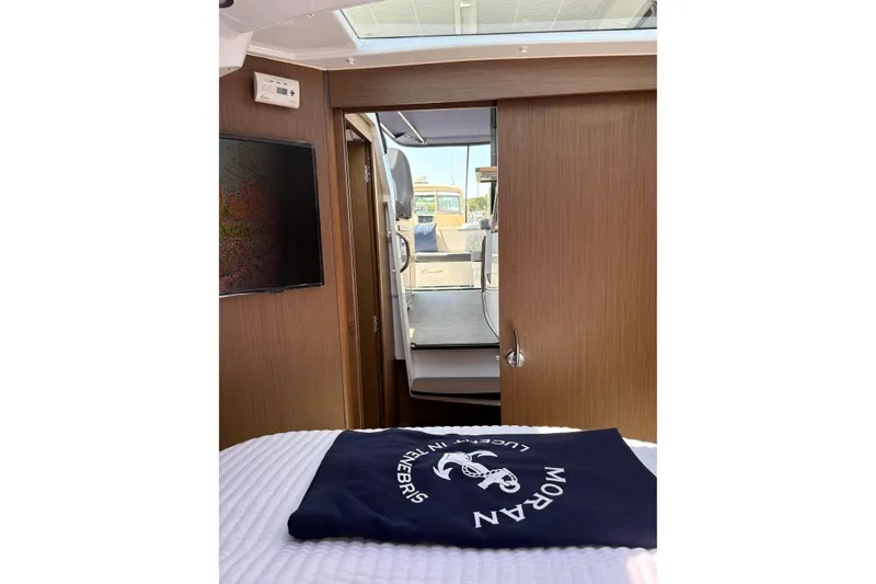 Slide: The Image of Interior view of 2020 Jeanneau NC 895 boat cabin with wooden finish and open door. - 14