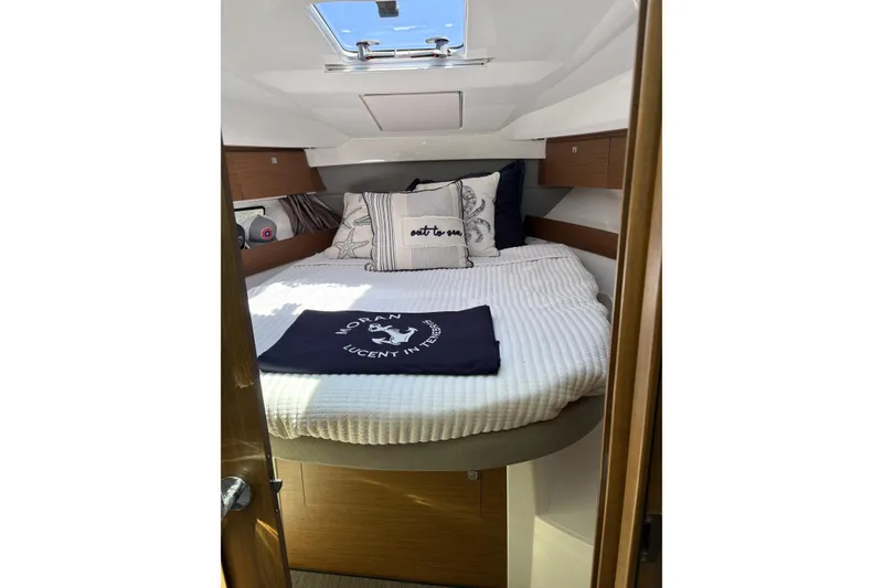 Slide: The Image of Cozy cabin interior of 2020 Jeanneau NC 895 with bed and nautical decor. - 16