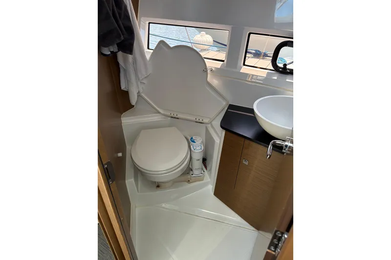 Slide: The Image of 2020 Jeanneau NC 895 boat bathroom with toilet, sink, and window view. - 17