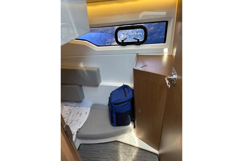 Slide: The Image of 2020 Jeanneau NC 895 cabin interior with window, storage, and seating area. - 18