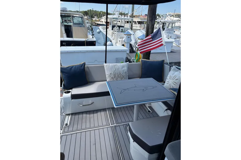Slide: The Image of Cozy seating area on 2020 Jeanneau NC 895 boat with American flag and nautical decor. - 6