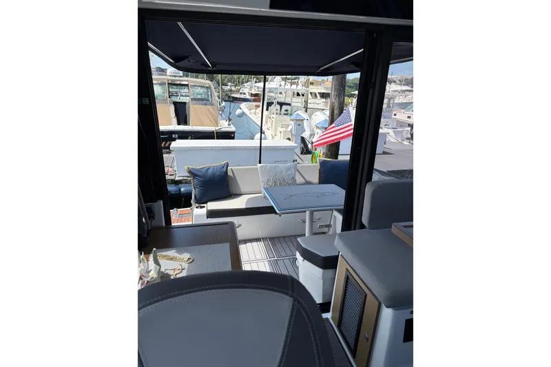 Slide: The Image of Interior view of 2020 Jeanneau NC 895 yacht with seating and table, docked at marina. - 7