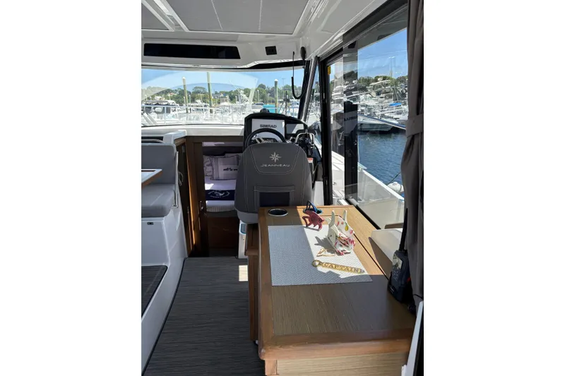 Slide: The Image of Interior of 2020 Jeanneau NC 895 boat with helm and table, docked at marina. - 8