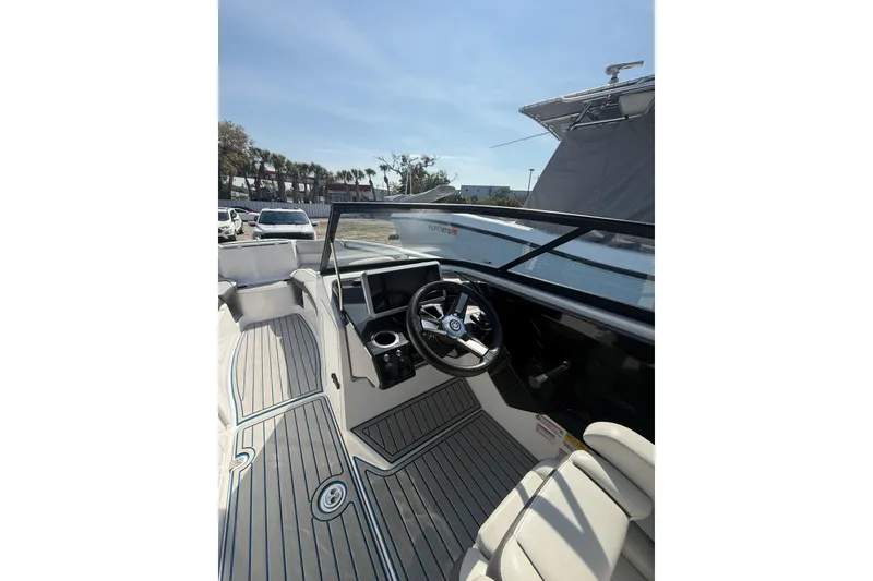 Slide: The Image of 2023 Yamaha Boats AR250 interior with steering wheel and seating, showcasing modern design. - 11
