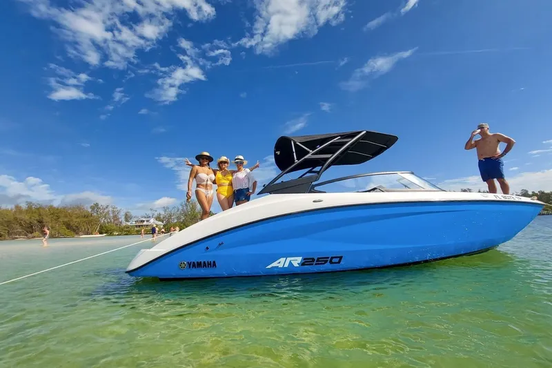 Slide: The Image of 2023 Yamaha AR250 boat with people enjoying a sunny day on the water. - 15