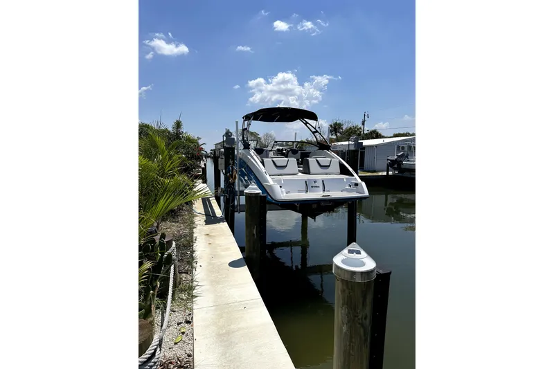 Slide: The Image of 2023 Yamaha Boats AR250 docked on a sunny day, reflecting in calm water. - 3