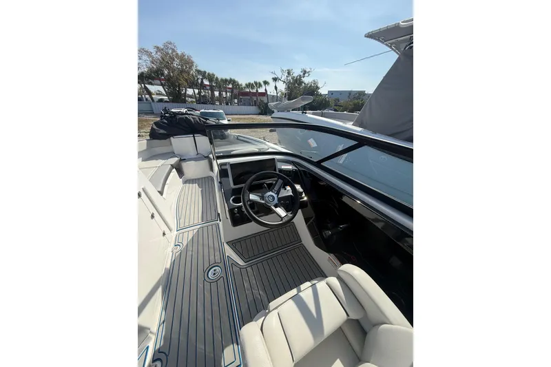 Slide: The Image of 2023 Yamaha Boats AR250 interior with sleek design and modern steering console. - 6