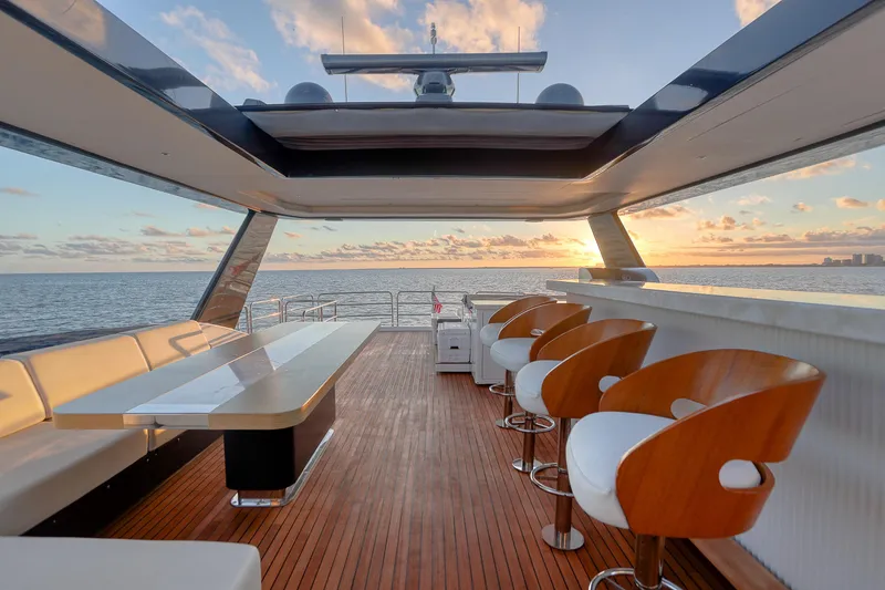 Slide: The Image of Luxurious Sirena 88 yacht deck with bar stools and ocean view at sunset, 2021 model. - 15