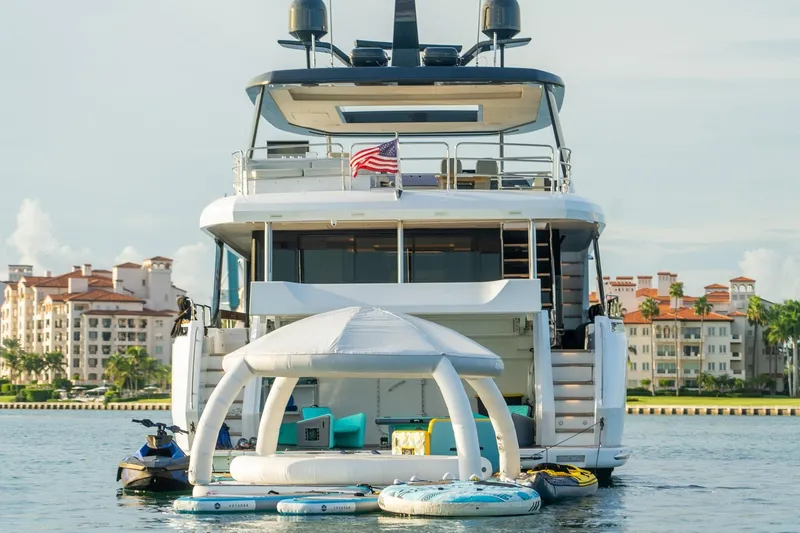 Slide: The Image of Luxury Sirena 88 yacht with inflatable water toys, docked near waterfront buildings. - 6