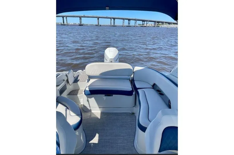 Slide: The Image of 2021 Crownline Eclipse E255 XS boat interior with seating, overlooking water and bridge. - 5