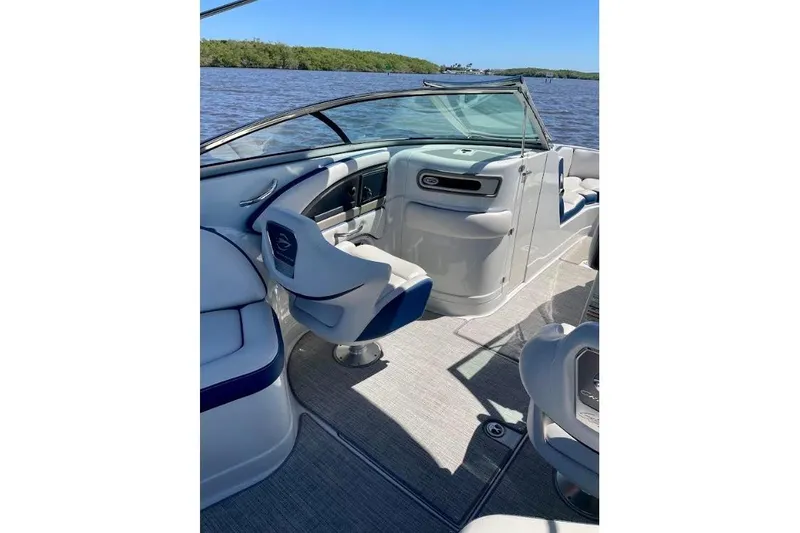 Slide: The Image of 2021 Crownline Eclipse E255 XS boat interior with seating and helm, on a sunny day. - 6