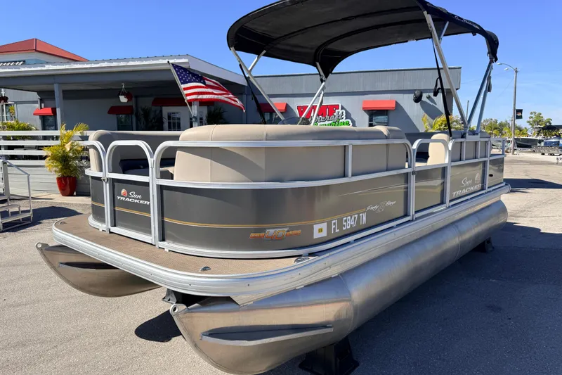 The Image of 2023 Sun Tracker Party Barge 18 DLX pontoon boat with canopy and American flag. - 1