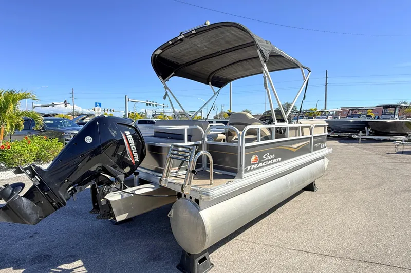 Slide: The Image of 2023 Sun Tracker Party Barge 18 DLX pontoon boat with Mercury engine, parked outdoors. - 5