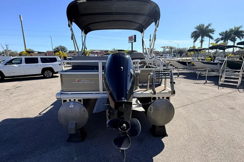 Slide: The Image of 2023 Sun Tracker Party Barge 18 DLX pontoon boat with outboard motor, parked outdoors. - 6