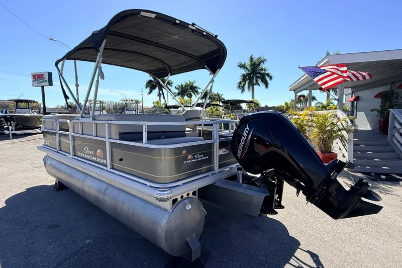 Slide: The Image of 2023 Sun Tracker Party Barge 18 DLX pontoon boat with Mercury engine, parked outdoors. - 7