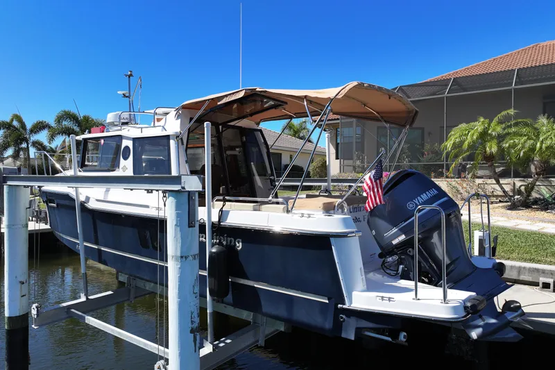 Slide: The Image of 2020 Ranger Tugs R-25 boat docked with Yamaha engine and American flag. - 1