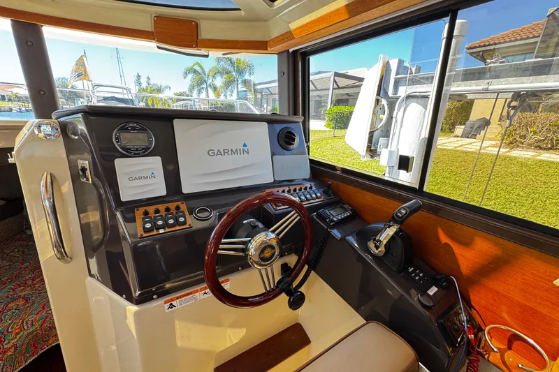 Slide: The Image of 2020 Ranger Tugs R-25 helm with Garmin navigation system and wooden steering wheel. - 12