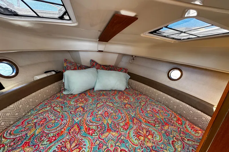 Slide: The Image of Cozy cabin interior of 2020 Ranger Tugs R-25 with colorful bedding and porthole windows. - 14