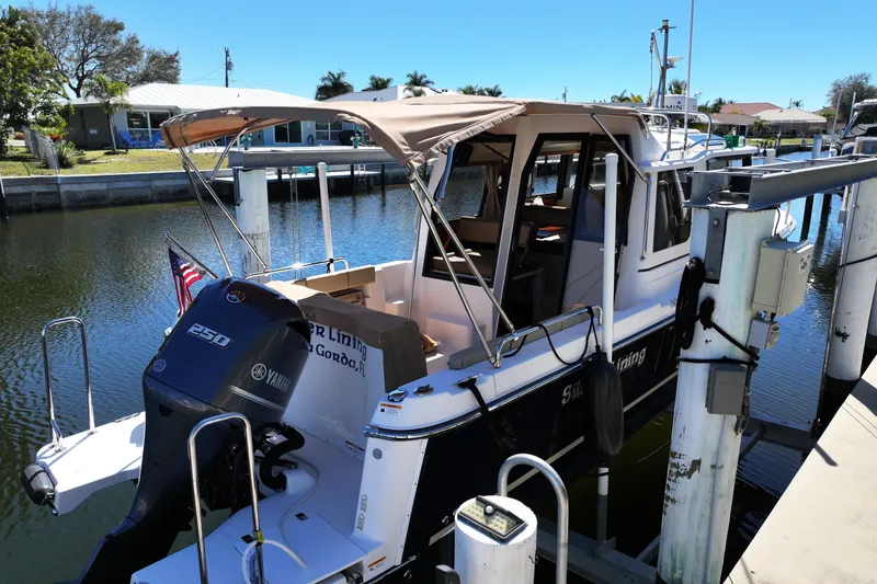 Slide: The Image of 2020 Ranger Tugs R-25 docked, featuring Yamaha 250 engine, in a sunny marina setting. - 4