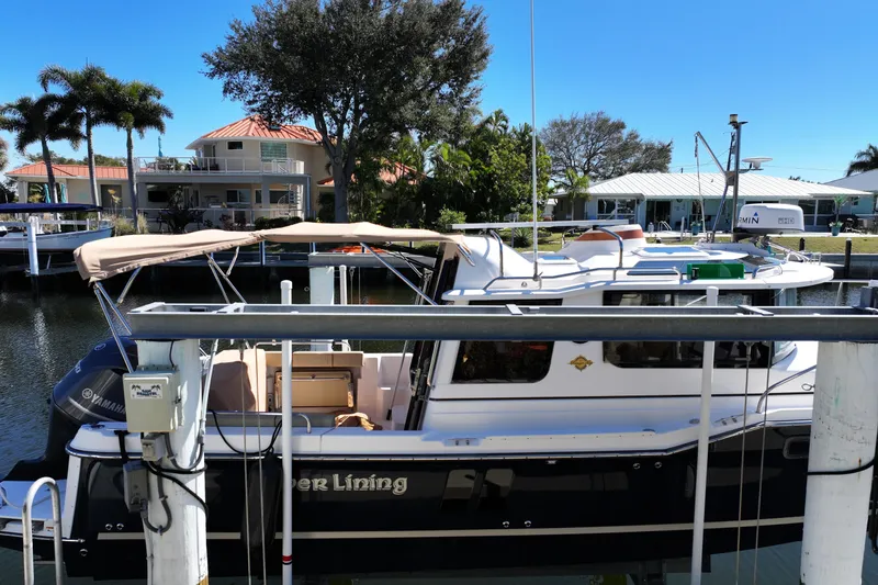 Slide: The Image of 2020 Ranger Tugs R-25 docked near waterfront homes, under clear blue sky. - 5