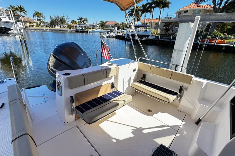 Slide: The Image of 2020 Ranger Tugs R-25 boat with seating area, docked in a scenic marina. - 7