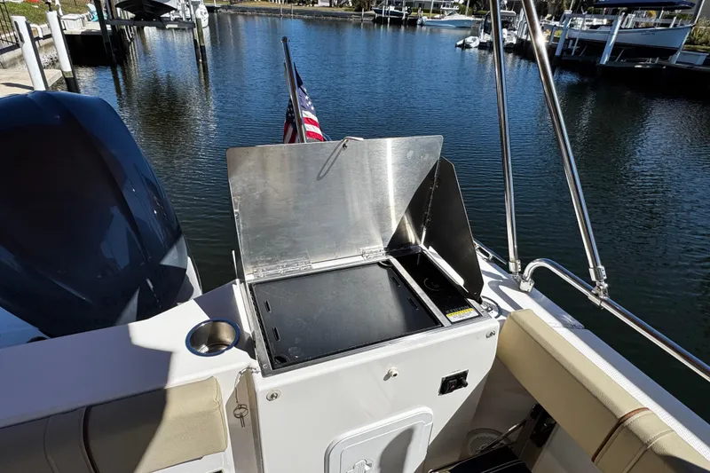 Slide: The Image of Outdoor grill on 2020 Ranger Tugs R-25 boat, docked by a serene waterfront. - 8